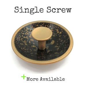 May include: A decorative brass single screw with a round head and a speckled black and gold bowl. The text "Single Screw" is above the screw. The text "More Available" is below the screw.
