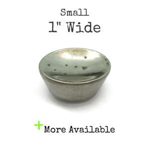 May include: A small, metallic, bowl-shaped object, approximately 1 inch wide, with a slightly textured surface. The text "Small" and "1" Wide" are printed above the object. The text "More Available" is printed below the object.