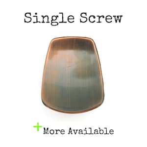 May include: A single, antique-style screw with a copper finish. The screw has a rounded, trapezoid shape. The text "Single Screw" is printed above the screw, and "More Available" is printed below.