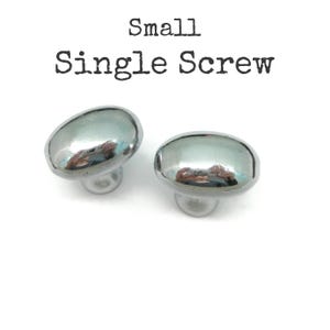 May include: Two small, oval-shaped cabinet knobs with a polished, reflective silver finish. Each knob features a single screw attachment point on the underside. The text "Small Single Screw" is printed in black above the two hardware pieces.