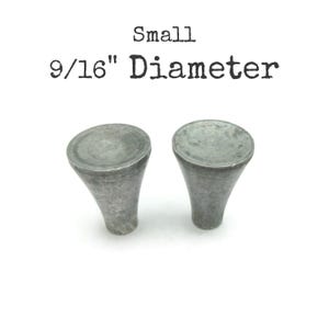 May include: Two small, gray metal cabinet knobs with a 9/16" diameter. The knobs have a rounded top and a flared, conical base. The word "Small" and "9/16" Diameter" are printed above the knobs.