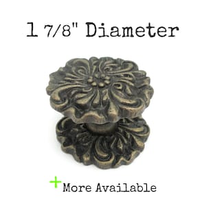 May include: A 1 7/8 inch diameter ornate, antique gold-toned cabinet knob with a floral design.