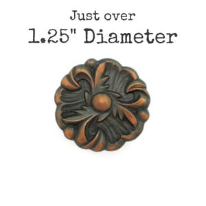 May include: Ornate, bronze-colored furniture knob with a floral design. The knob is approximately 1.25 inches in diameter. The text "Just over 1.25" Diameter" is above the knob.