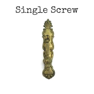 May include: A single, ornate brass screw with a decorative handle. The screw features an intricate design with floral and scrollwork details. The text "Single Screw" is printed above the screw.