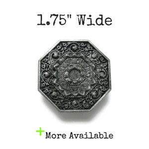 May include: A silver-toned, octagonal-shaped decorative button with an intricate, floral design. The button is 1.75 inches wide.