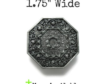 Puede incluir: Un botón octogonal de metal plateado con un intrincado patrón en relieve de círculos concéntricos y detalles de filigrana. El botón mide 1,75 pulgadas de ancho e incluye el texto 1.75" Wide y More Available.