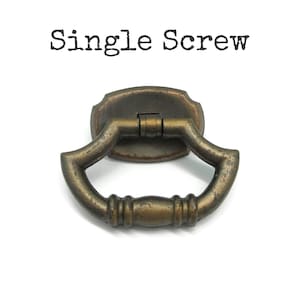May include: A bronze-toned metal drop pull handle featuring a curved, textured design with a central mounting plate. The text "Single Screw" is printed in black above the hardware, indicating the installation method for this furniture component.