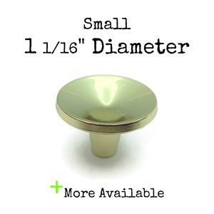 May include: A small, gold-coloured metal knob with a 1 1/16" diameter. The knob is shaped like a cone with a rounded top.