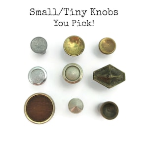 May include: Assortment of small, decorative knobs in various shapes, colors, and finishes.  The knobs are made of metal and wood.  The text "Small/Tiny Knobs You Pick!" is written above the knobs.