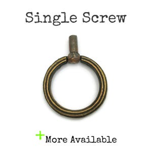 May include: A single antique brass screw with a circular ring design. The ring has a grooved texture and is attached to a cylindrical post. The text "Single Screw" is above the screw, and "More Available" is below.
