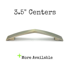 May include: A silver-toned cabinet pull with a V-shaped design. The text "3.5" Centers" is above the pull, and "More Available" is below. The pull measures 3.5 inches in length.