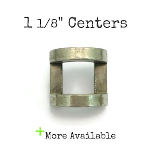 May include: A white ceramic mug with a black handle and the text "But First, Coffee" in a bold, black font. The mug is set against a blurred background, suggesting a cozy setting. The mug appears to be approximately 4 inches tall.