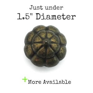 May include: An antique-style, bronze-colored knob with a floral design. The knob is just under 1.5 inches in diameter. Text on the image reads "Just under 1.5" Diameter" and "More Available".