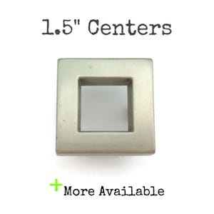 May include: A silver square cabinet knob with a 1.5" center to center measurement.