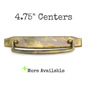 May include: A 4.75 inch center antique brass cabinet pull with a rectangular base and a curved handle.