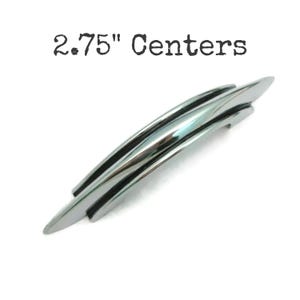 May include: A polished chrome cabinet pull with a curved design. The text "2.75" Centers" is above the pull. The hardware is approximately 2.75 inches in length, suitable for various furniture applications.