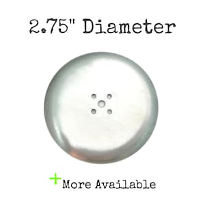 May include: A silver-colored, circular object with a diameter of 2.75 inches. It has a slightly domed shape and a series of small holes in the center. The text "2.75" Diameter" is at the top, and "More Available" is at the bottom.