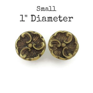 May include: A set of three ceramic mugs with a speckled, matte finish. The mugs are in shades of cream, light gray, and dark gray. Each mug has a simple, minimalist design and a rounded handle.