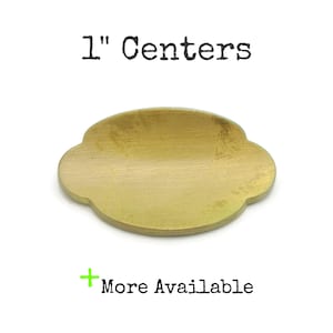 May include: A brass-colored, cloud-shaped hardware piece with the text "1" Centers" above it. The text "More Available" is below the hardware piece.