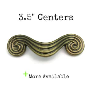 May include: A 3.5" center antique brass cabinet pull with a swirling design.
