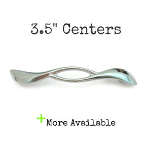 May include: A white ceramic mug with a black handle and the text "But First, Coffee" in a black, bold font. The mug is sitting on a white surface. The mug is approximately 4 inches tall.