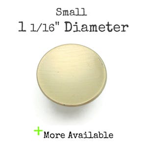 May include: A small, round, brass-colored cabinet knob with a diameter of 1 1/16 inches. The text "Small 1 1/16" Diameter" is above the knob, and "More Available" is below.