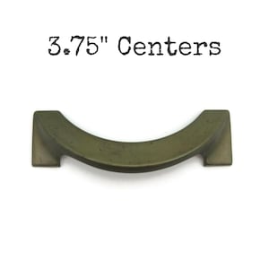 May include: A bronze-colored cabinet pull with a curved design. The text "3.75" Centers" is above the pull. The pull is approximately 3.75 inches wide, with a curved center and square ends.