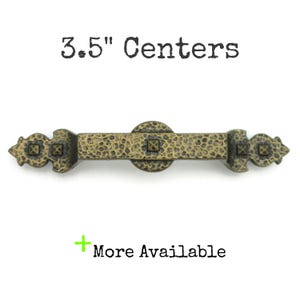 May include: A bronze-colored cabinet pull with a hammered texture and decorative end pieces. The text "3.5" Centers" is above the pull, and "More Available" is below. The pull measures 3.5 inches in length.