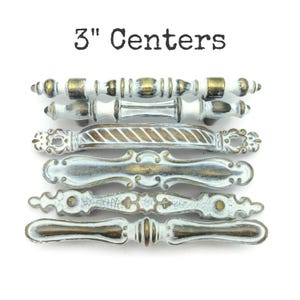 May include: A set of three ceramic mugs with a speckled, matte finish. The mugs are in shades of cream, light gray, and dark gray. Each mug has a simple, minimalist design, perfect for coffee or tea.