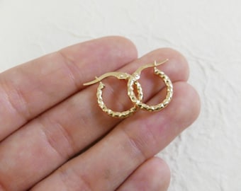May include: A pair of gold hoop earrings with a textured surface.