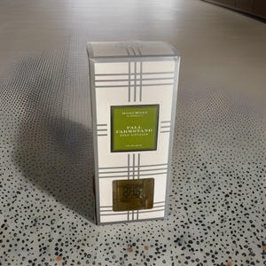May include: A rectangular reed diffuser box with a white and gray plaid pattern. The box features a green label with the text "FALL FARMSTAND REED DIFFUSER" and "4 fl oz / 120 ml". The brand name "HOMEWORK" is also visible.