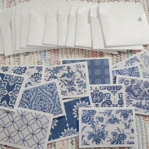 May include: A collection of white envelopes with scalloped edges and a variety of blue and white patterned cards. The cards feature floral, geometric, and toile designs, perfect for stationery or crafting projects.