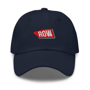 Puede incluir: Gorra de béisbol azul marino con visera curva. La gorra presenta la palabra "ROW" bordada en blanco dentro de un diseño rectangular rojo y blanco en la parte delantera. Tiene una construcción clásica de seis paneles y una correa ajustable.