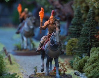 May include: A miniature figurine of a mounted warrior in metallic armor with a red-crested helmet, riding a grey horse. The warrior holds a glowing orange torch. A second mounted figure is visible in the background. The logo IVYROCK is visible.