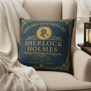 Może przedstawiać: Kwadratowa poduszka z ciemnoniebieskim tłem i złotymi literami. Poduszka zawiera napis "The Adventures of Sherlock Holmes" oraz sylwetkę Sherlocka Holmesa. Dołączono również nazwisko autora, Sir Arthur Conan Doyle.