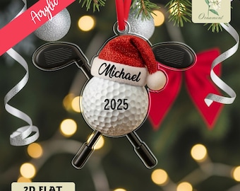 Puede incluir: Adorno navideño acrílico con una pelota de golf con gorro de Papá Noel, el nombre "Michael" y el año "2025". Dos palos de golf se cruzan detrás de la pelota. El adorno es un diseño plano 2D.