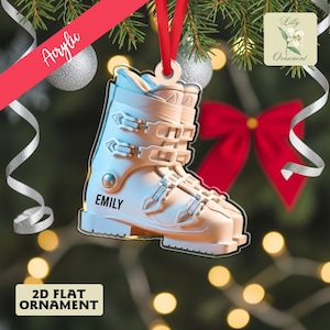 Puede incluir: Adorno navideño de bota de esquí acrílica blanca con el nombre "EMILY". El adorno está suspendido por una cinta roja. El texto "2D FLAT ORNAMENT" está en la parte inferior. La palabra "Acrylic" está escrita en una pancarta diagonal roja.