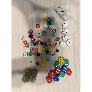 May include: A large collection of multi-colored six-sided dice in various sizes, including solid colors like red, blue, green, yellow, and white, as well as translucent and speckled varieties, scattered across the frame with some stacked.