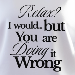 May include: A white crewneck sweatshirt featuring black text that reads, "Relax? I would... but You are Doing it Wrong." The garment has long sleeves and a round neckline, with a yellow star-shaped graphic in the upper left corner labeled "White."