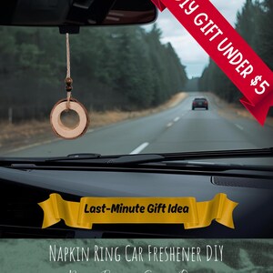 May include: A car interior shot featuring a DIY car air freshener suspended from the rearview mirror. The freshener is a wooden ring on a cord. The image includes text: "DIY GIFT UNDER £5" and "Last-Minute Gift Idea".