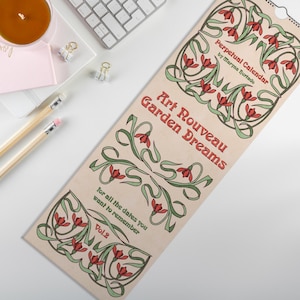 Può includere: Un calendario perpetuo con un design Art Nouveau, con il testo "Art Nouveau Garden Dreams" e "Perpetual Calendar". Il calendario ha uno sfondo beige con illustrazioni floreali rosse e verdi. Include il testo "For all the dates you want to remember Vol.2."