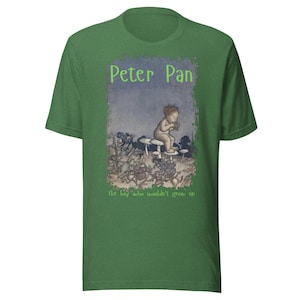Puede incluir: Camiseta verde con una ilustración vintage de Peter Pan. El diseño incluye el texto "Peter Pan" en verde sobre una imagen de un niño sentado en setas, con el texto "the boy who wouldn't grow up" debajo.