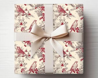 May include: A wrapped gift with a cream-colored ribbon and bow. The wrapping paper features a repeating pattern of red birds perched on branches with berries and evergreen foliage against a cream background. The overall theme is festive.