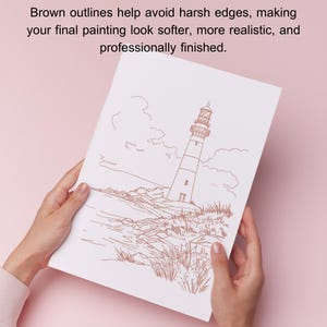 May include: A white paper with a brown outline drawing of a lighthouse on a rocky shore. The text at the top reads, "Brown outlines help avoid harsh edges, making your final painting look softer, more realistic, and professionally finished."