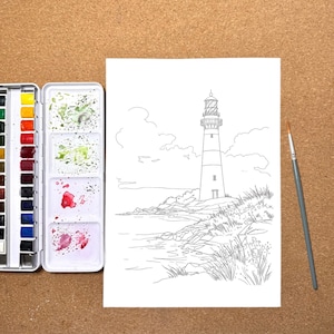 May include: A watercolor painting kit with a lighthouse outline drawing on white paper. The kit includes a palette of colorful paints and a paintbrush, all set on a brown surface.