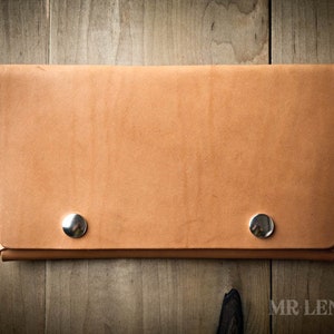 May include: A light brown leather wallet with two silver metal snaps.