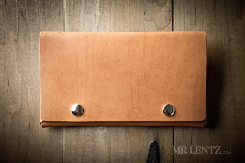 May include: A light brown leather wallet with two silver metal snaps.