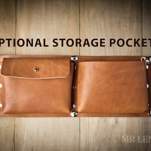 Pode incluir: Dois bolsos de armazenamento de couro castanho com rebites prateados e uma fivela prateada. Os bolsos est&atilde;o presos a um suporte de couro castanho. O texto "OPTIONAL STORAGE POCKETS" est&aacute; acima dos bolsos.