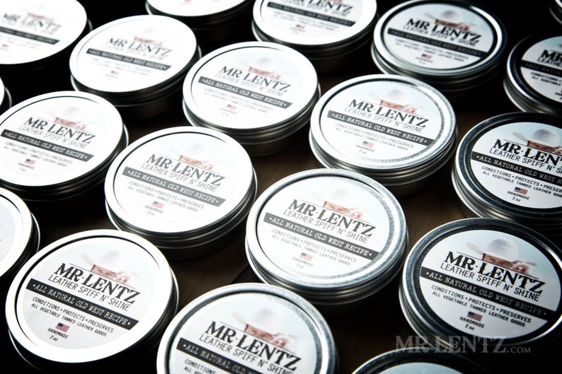 May include: Multiple silver tins of leather conditioner with the label "Mr. Lentz Leather Spiff 'n Shine - All Natural Old West Recipe".