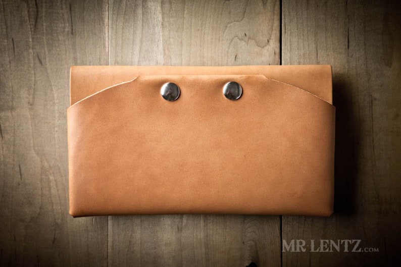 May include: A tan leather wallet with two silver snaps.
